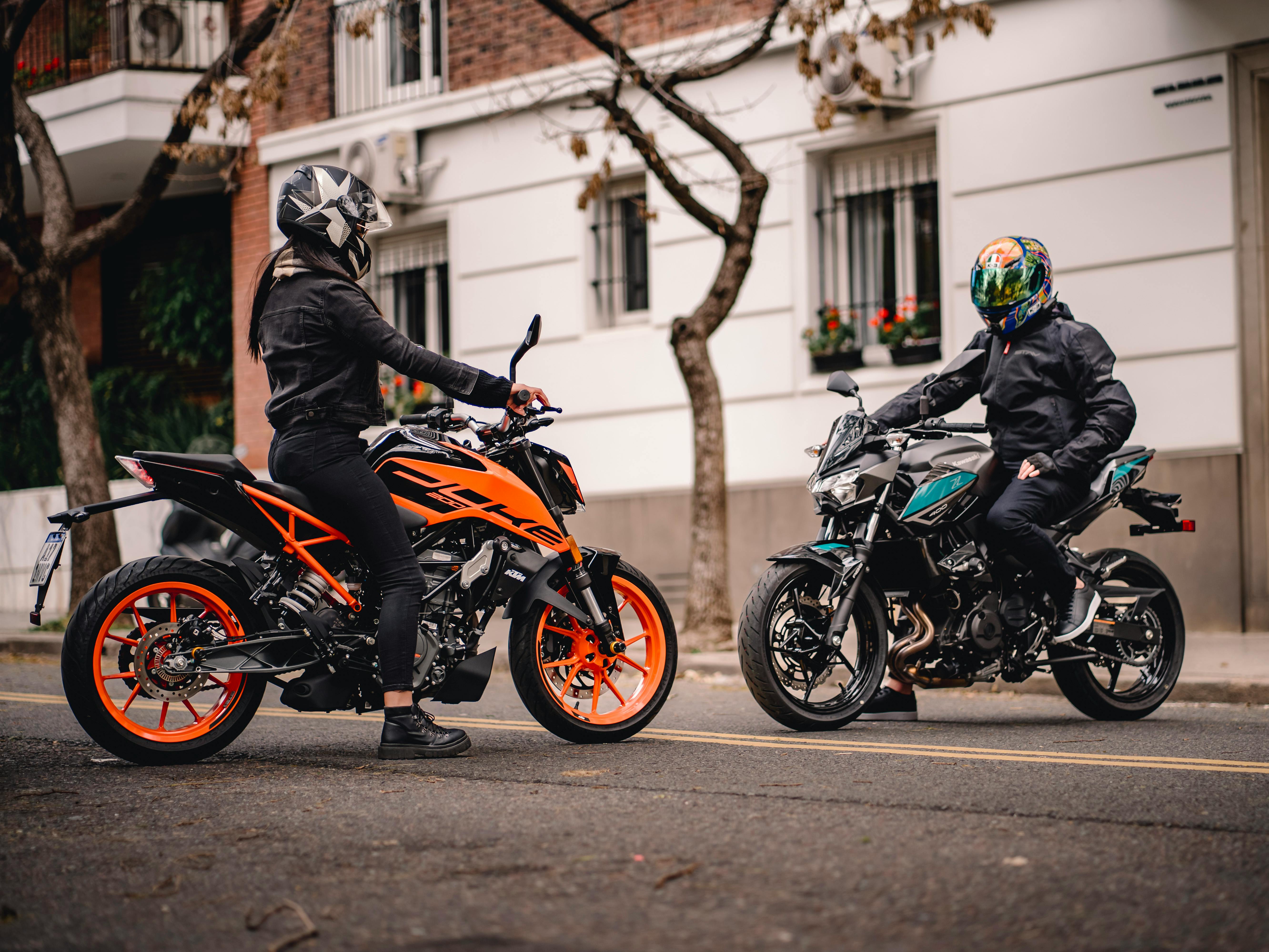 Free Two motorcyclists on vibrant bikes in a city street setting. Stock Photo