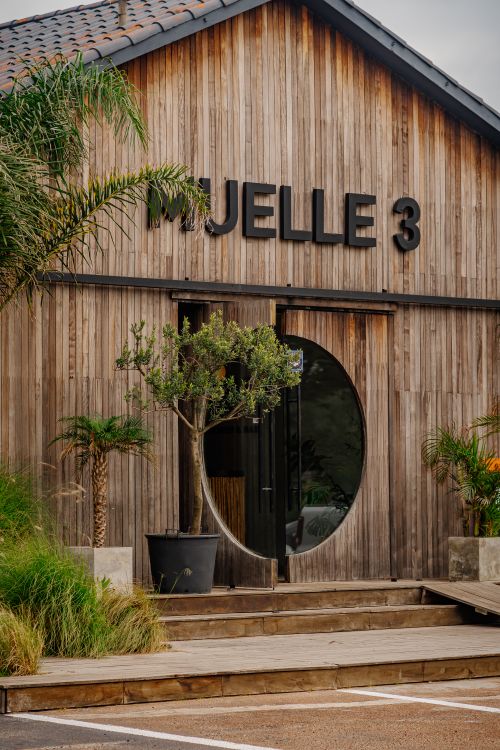 Free Rustic wooden entrance in Punta del Este with circular door and tropical plants. Stock Photo