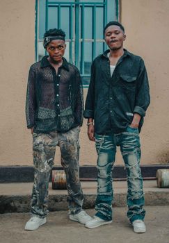 Street fashion shoot featuring two stylish young men posing outdoors.