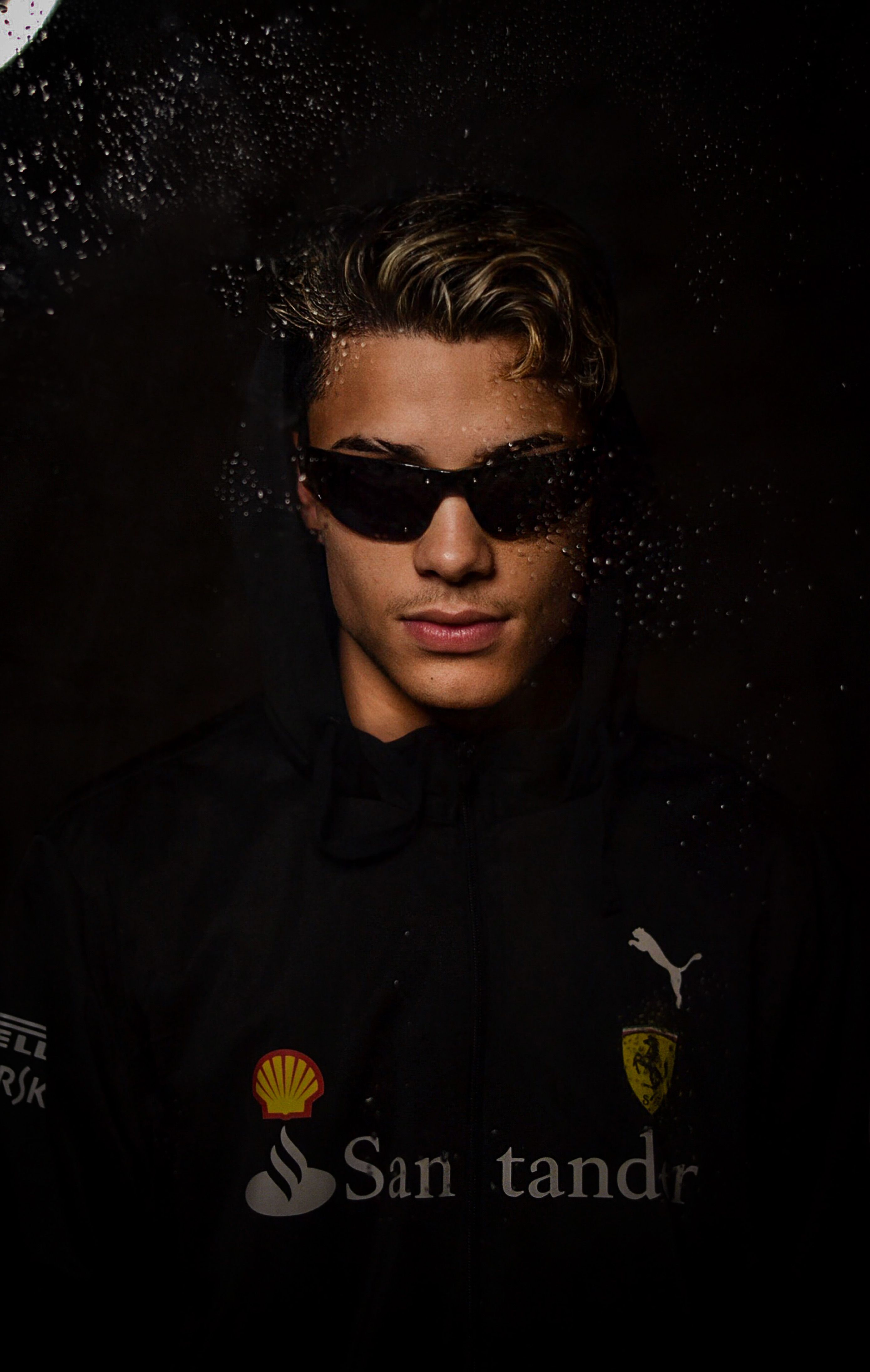 A fashionable man in sunglasses and a hoodie against a dark background. Mysterious and modern.