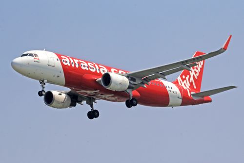 Free AirAsia Airbus A320 soaring through a clear blue sky. Stock Photo