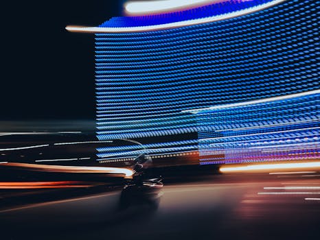 Blurred motion of car and colorful lights at night in Kolkata, India.