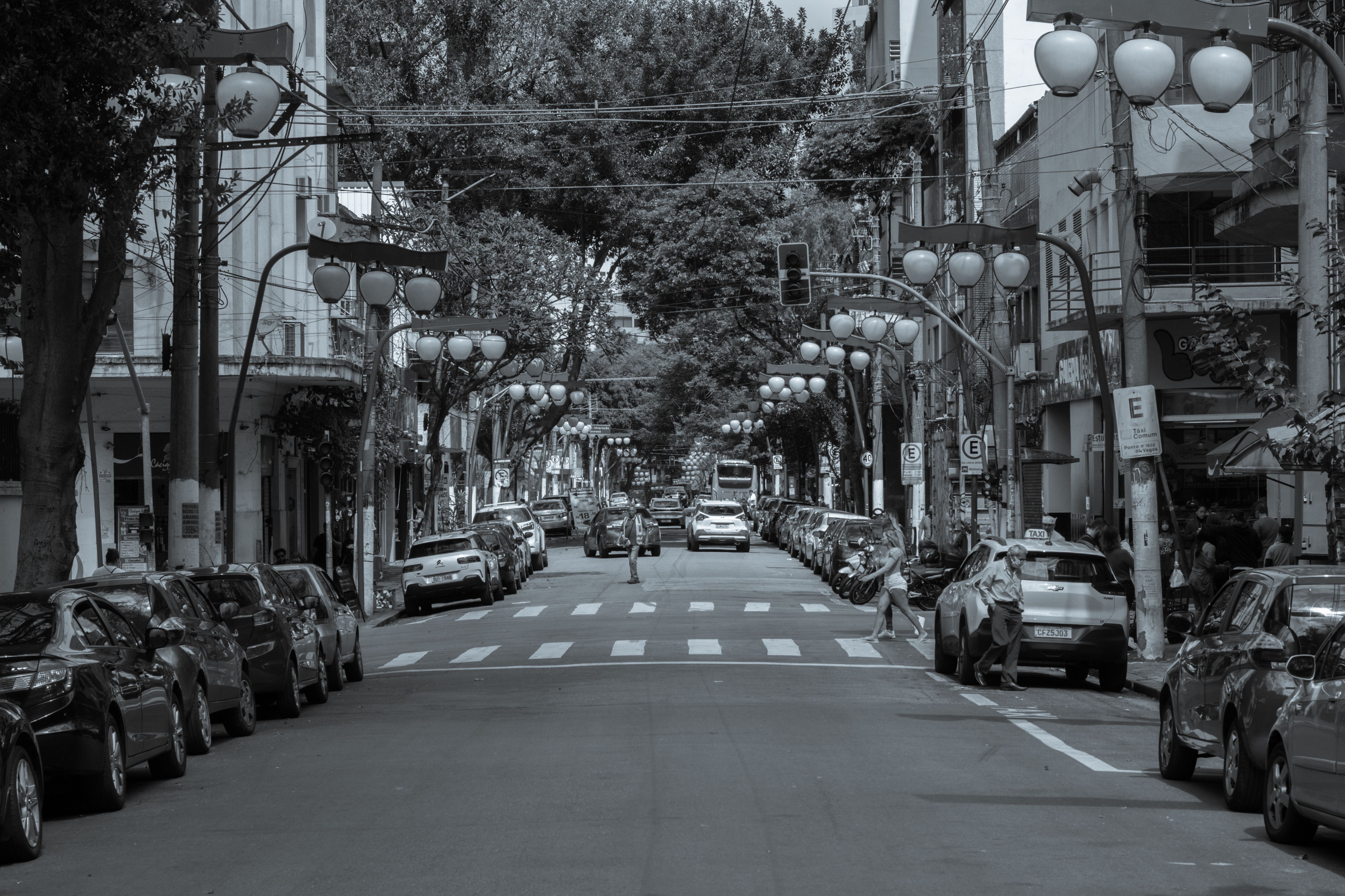Black and white image of a bustling São Paulo street filled with cars and pedestrians.