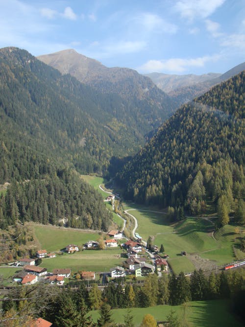 Free View of Houses in a Green Mountain Valley  Stock Photo