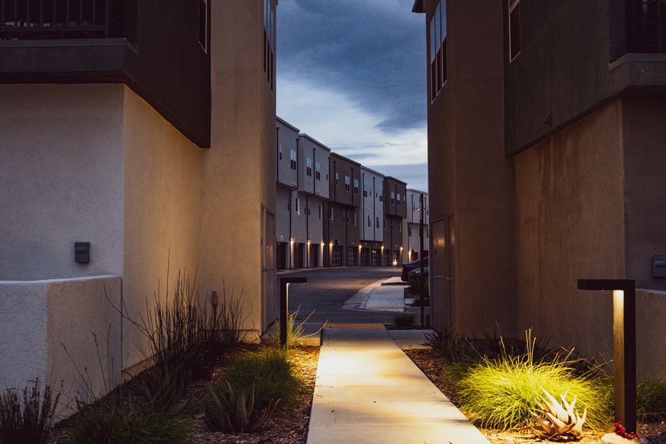 A serene view of a modern urban alley at twilight with contemporary architecture and lights.