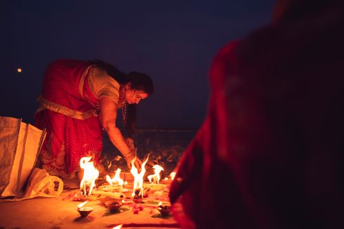 Free Woman in sari performs a night ritual with fire, embracing Indian tradition and spirituality. Stock Photo
