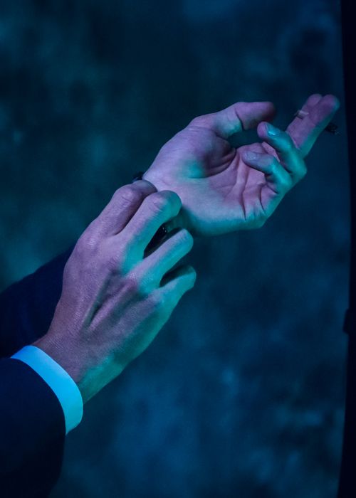 Free Close-up of elegant hands adjusting cufflinks under neon green light, capturing a nightlife atmosphere. Stock Photo