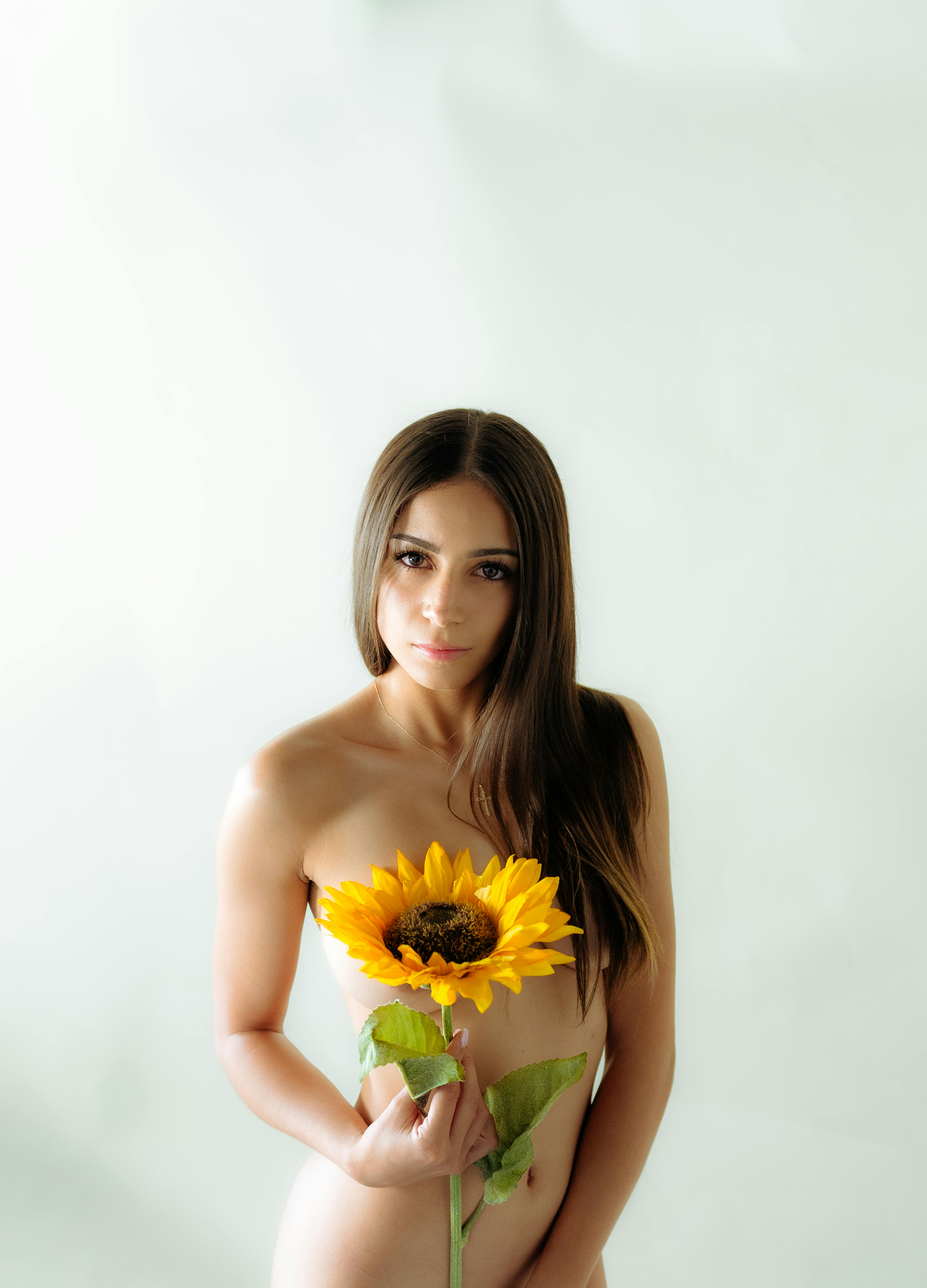 Naked Young Woman Holding a Sunflower · Free Stock Photo