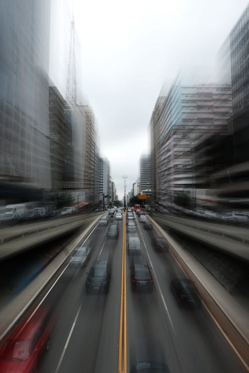 Time Lapse Photography of Moving Cars on the Road Between High Rise Buildings
