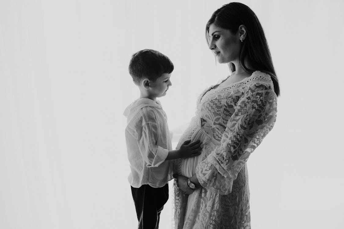 Son Standing with Pregnant Mother in Black and White