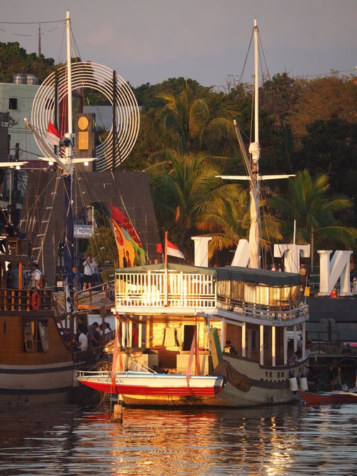 Free A beautiful view of moored tourist boats at a lively harbor, captured during sunset. Stock Photo
