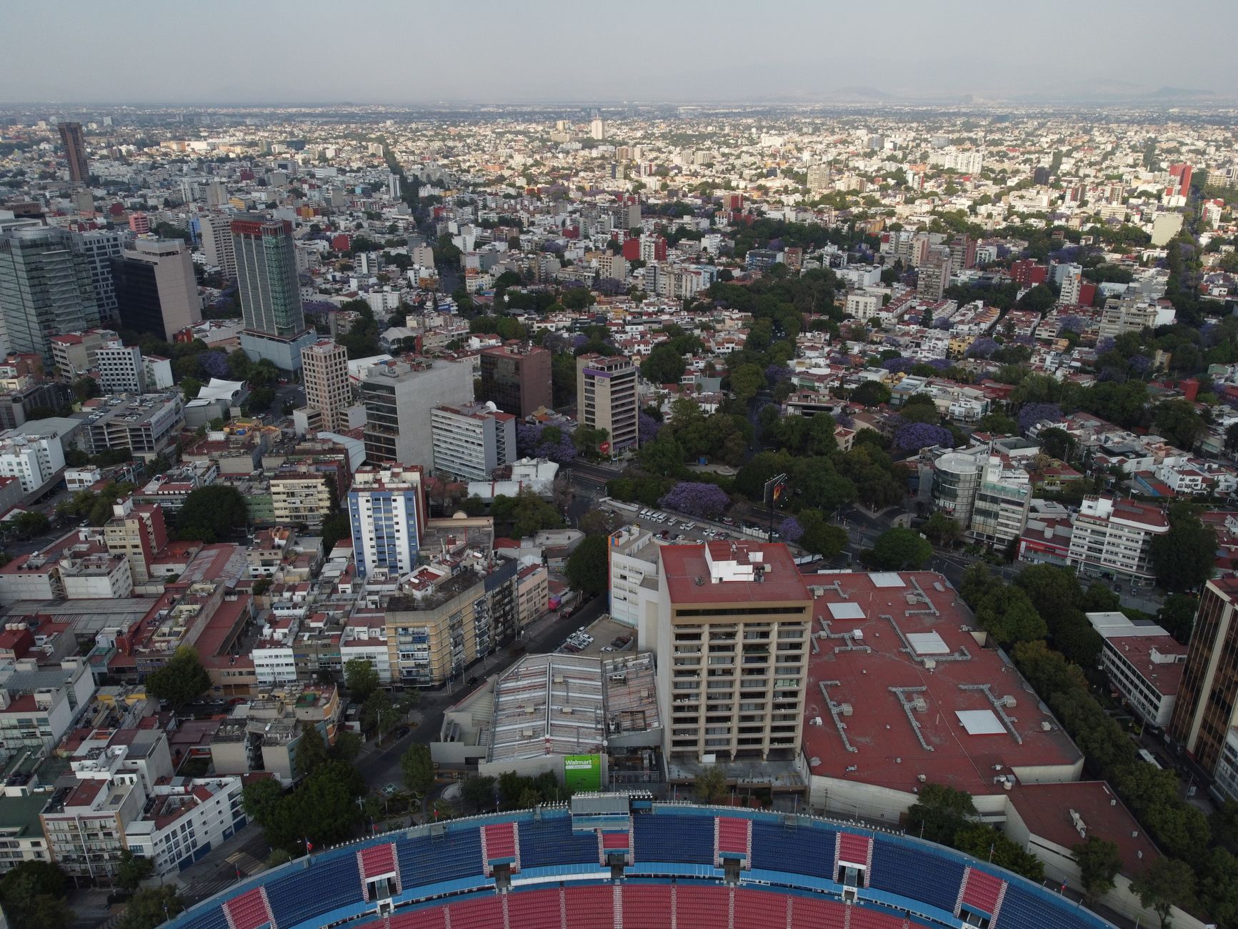 Estadio Azteca surrounded by Mexican supporters carrying national flags beneath a dramatic evening sky