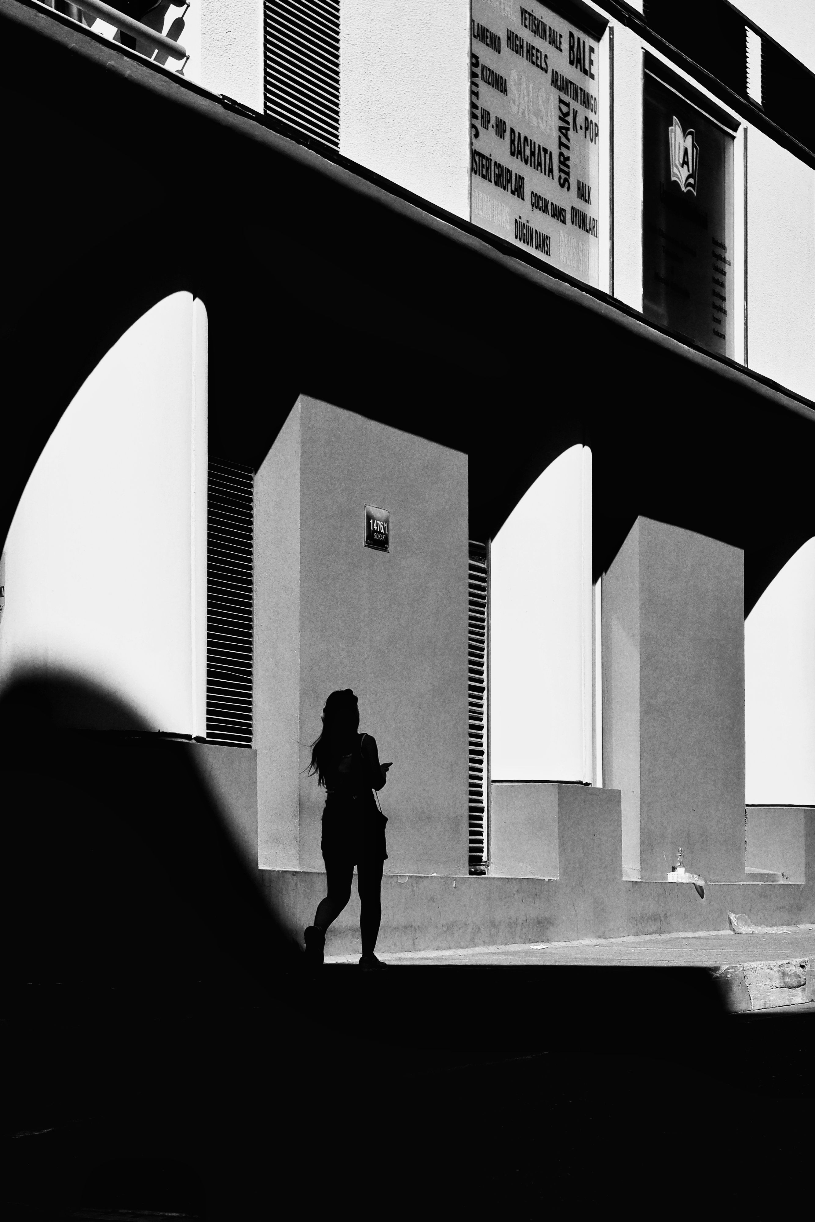 Silhouette of a Woman Walking on a Street in Black and White · Free ...