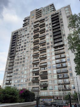 High-rise building featuring numerous balconies in a lively urban environment.