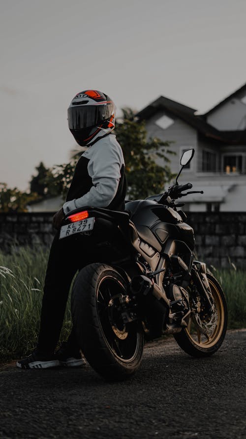 Man Standing Next to a Motorbike