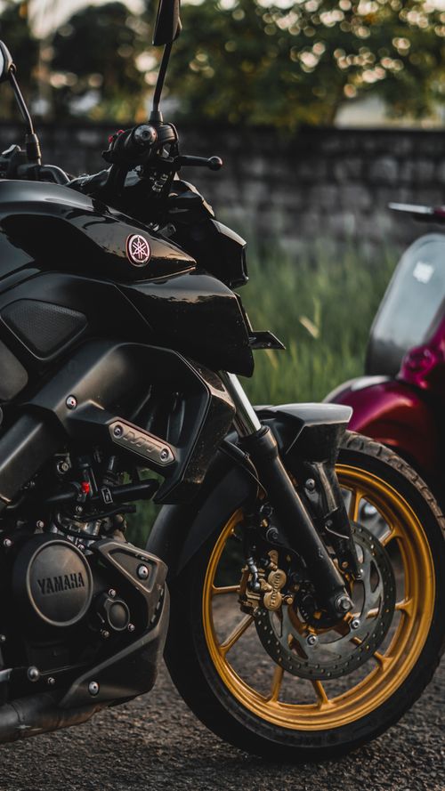 Free A detailed view of stylish parked motorcycles in an outdoor field setting, showcasing design and engineering. Stock Photo
