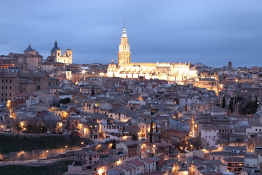 Stunning view of Toledo's skyline and Cathedral illuminated at twilight, showcasing gothic architecture.