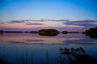 Serene twilight reflections on Evijärvi Lake with a wooden pier in Finland.
