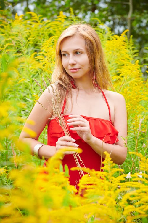 Woman in Red Strap Dress Standing among High Plants