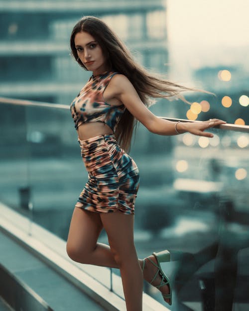 Woman in a Dress Posing on a Balcony of a Modern Building in City 