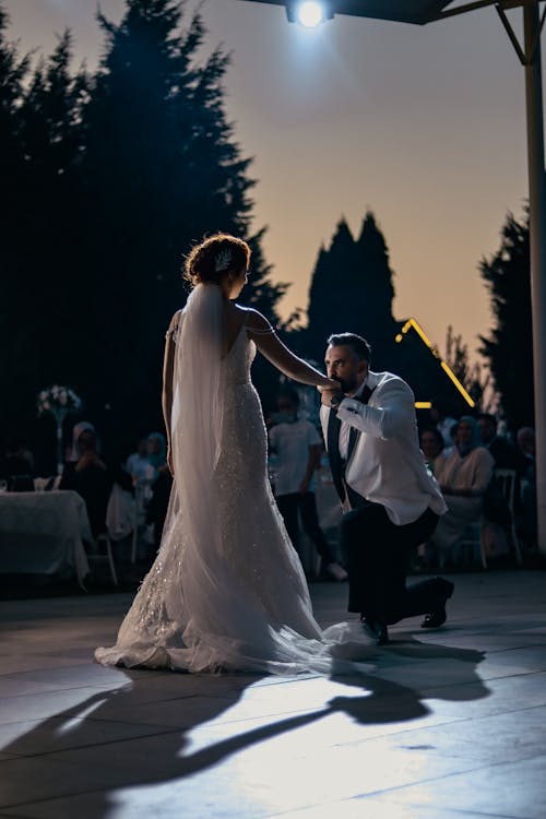 Man Kneeling in Front of a Bride