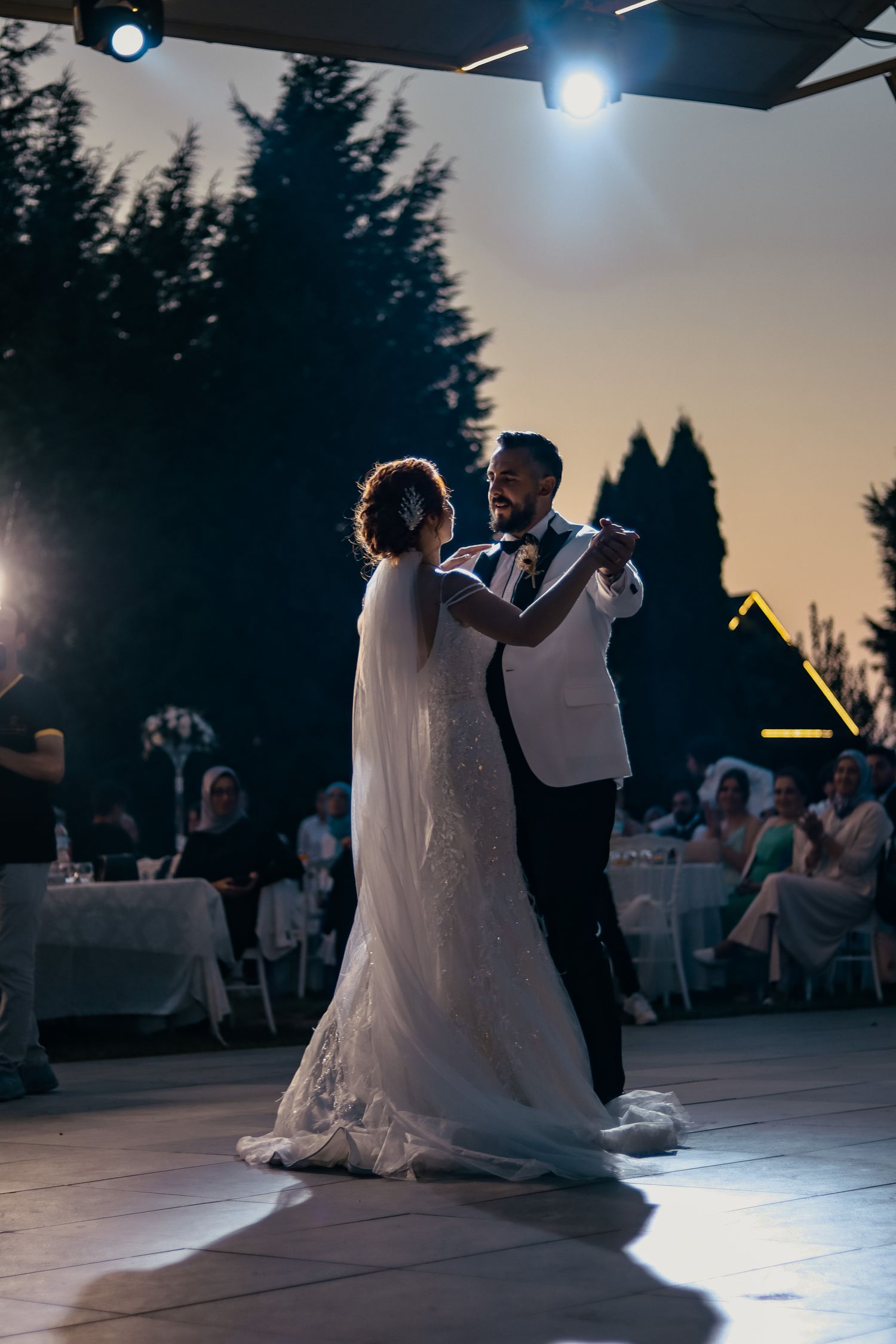 Bride and groom romantic first dance outdoors at twilight