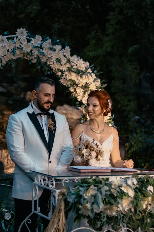 Free Bride and Groom Standing by a Table Stock Photo