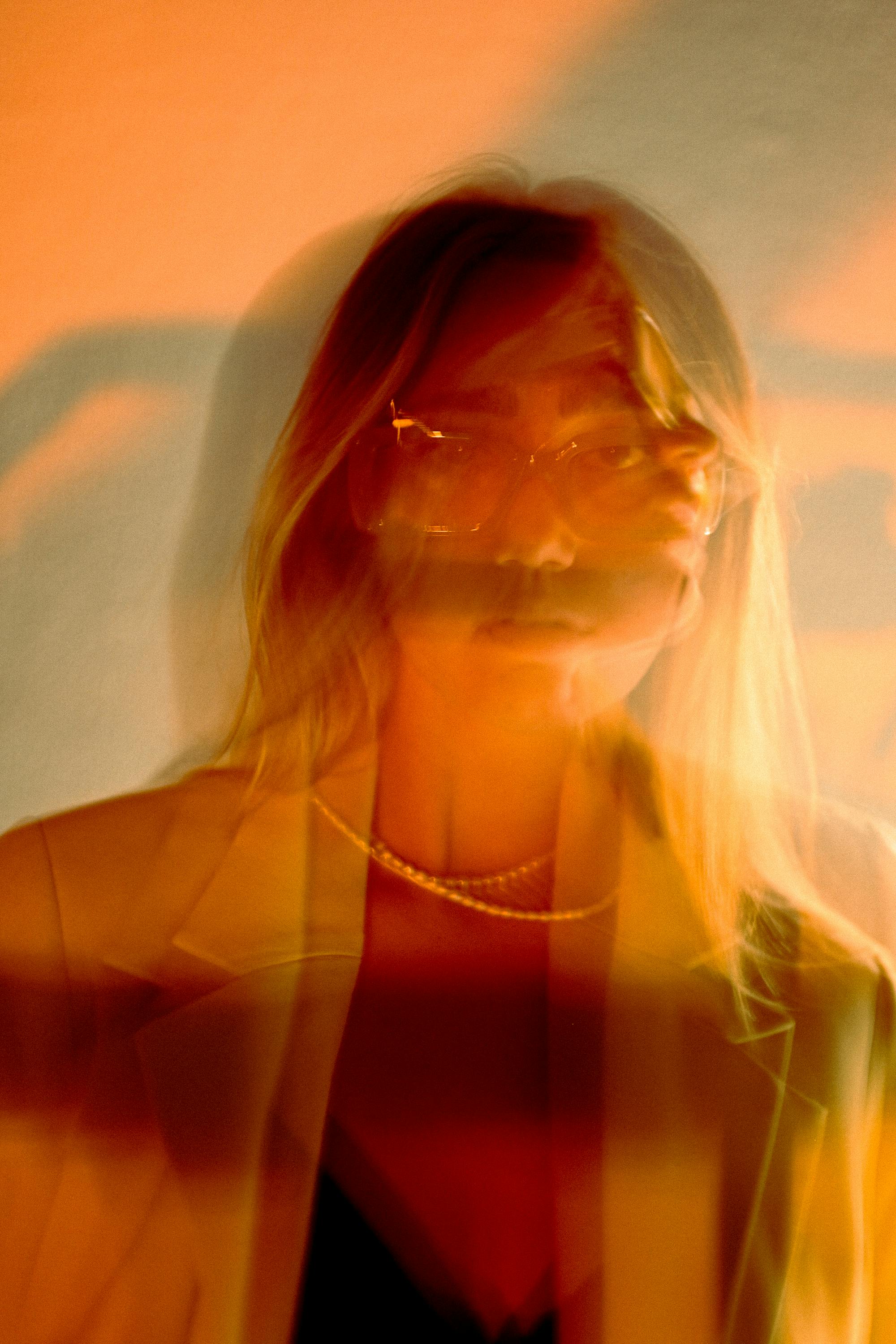 Creative long exposure portrait of a woman with eyeglasses and warm colors.