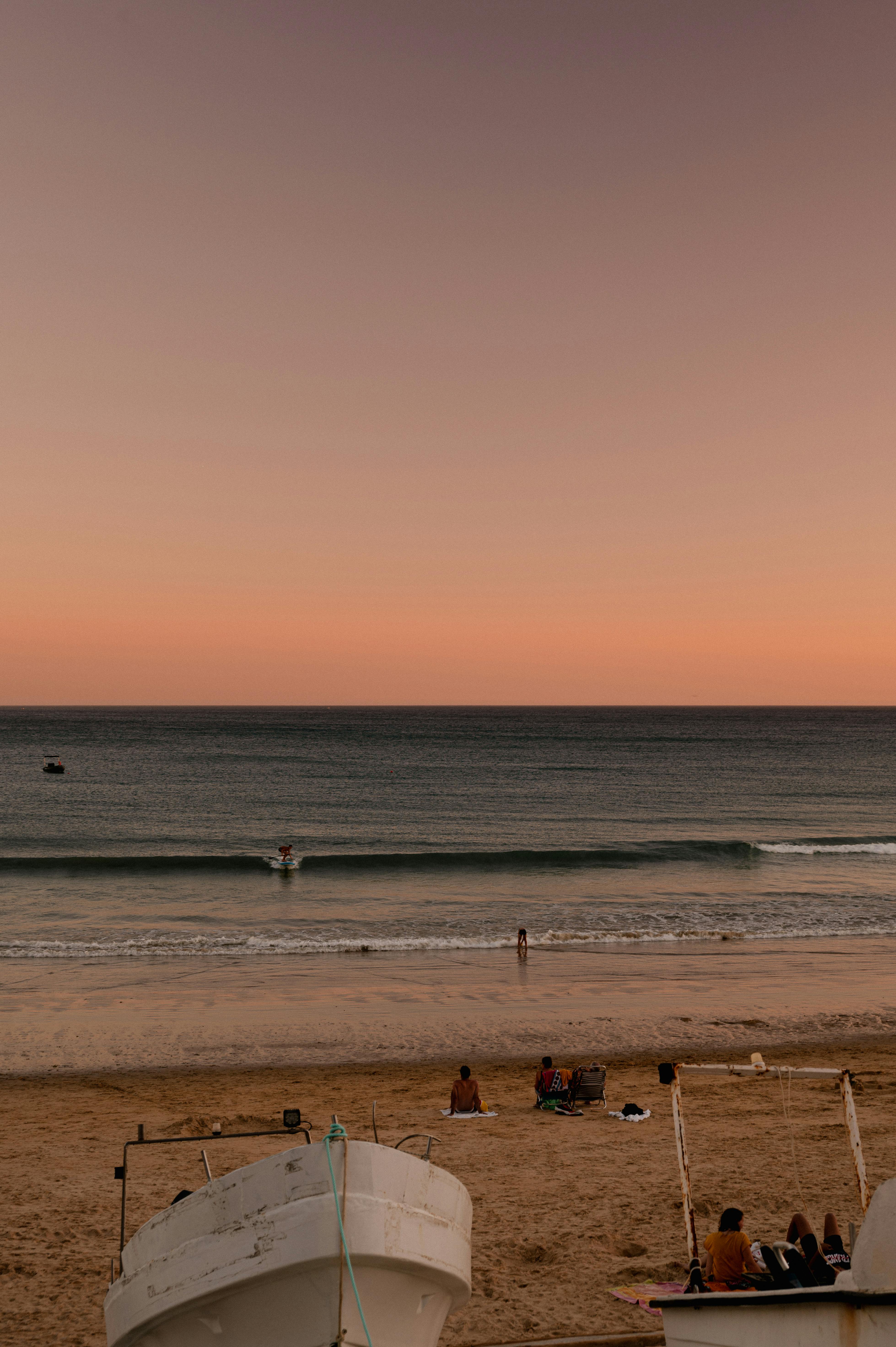 Seminyak beach club daybeds at golden hour with surf and sunset in the background in Bali
