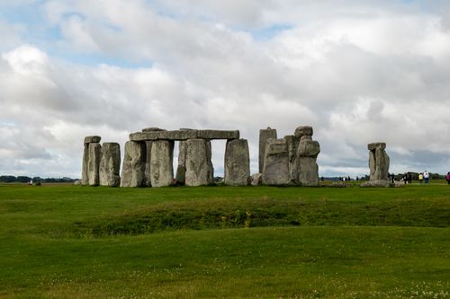 Free Explore the ancient Stonehenge landmark surrounded by lush grass and dramatic clouds, perfect for travel enthusiasts. Stock Photo