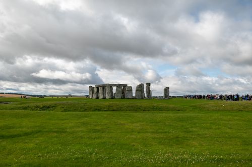 Free Captivating view of Stonehenge with tourists under a cloudy sky, showcasing its historic allure. Stock Photo