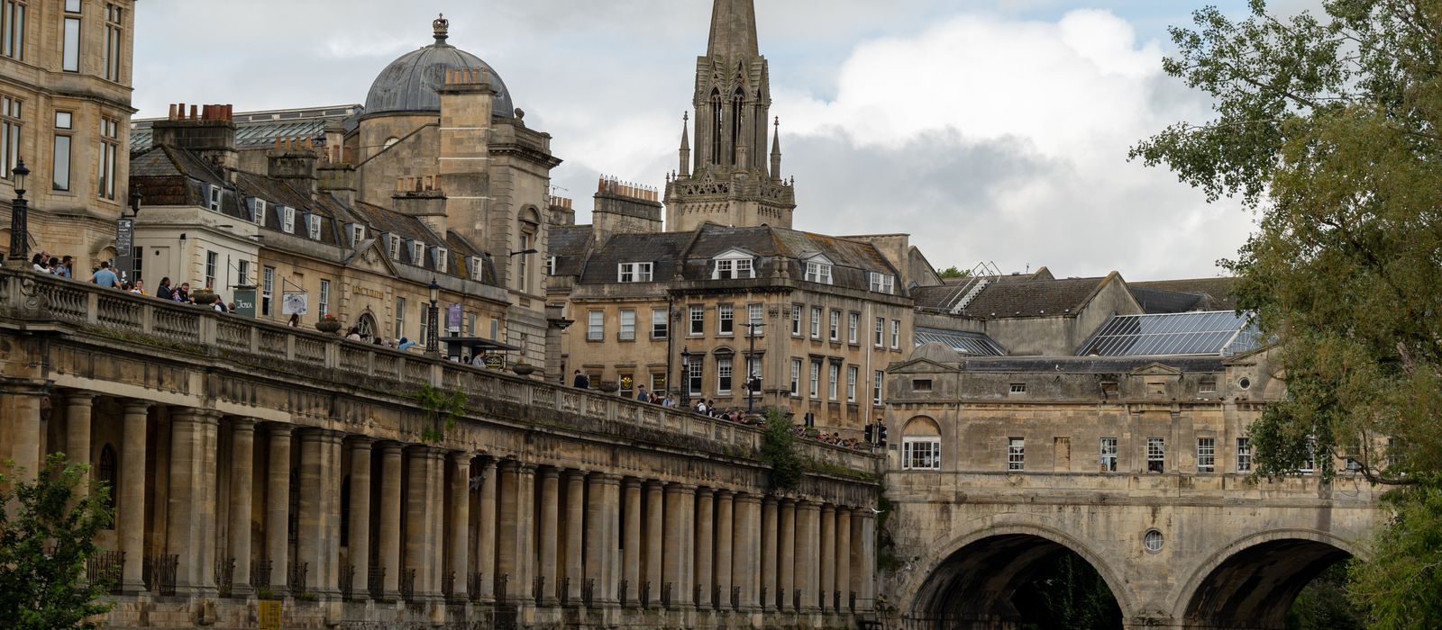 Scenic view of Pulteney Bridge spanning the river in Bath, England with historic architecture.