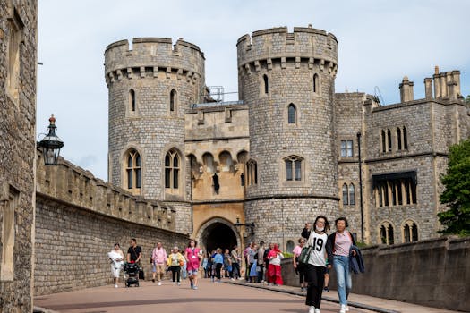 A lively scene with tourists exploring the medieval Windsor Castle in England.