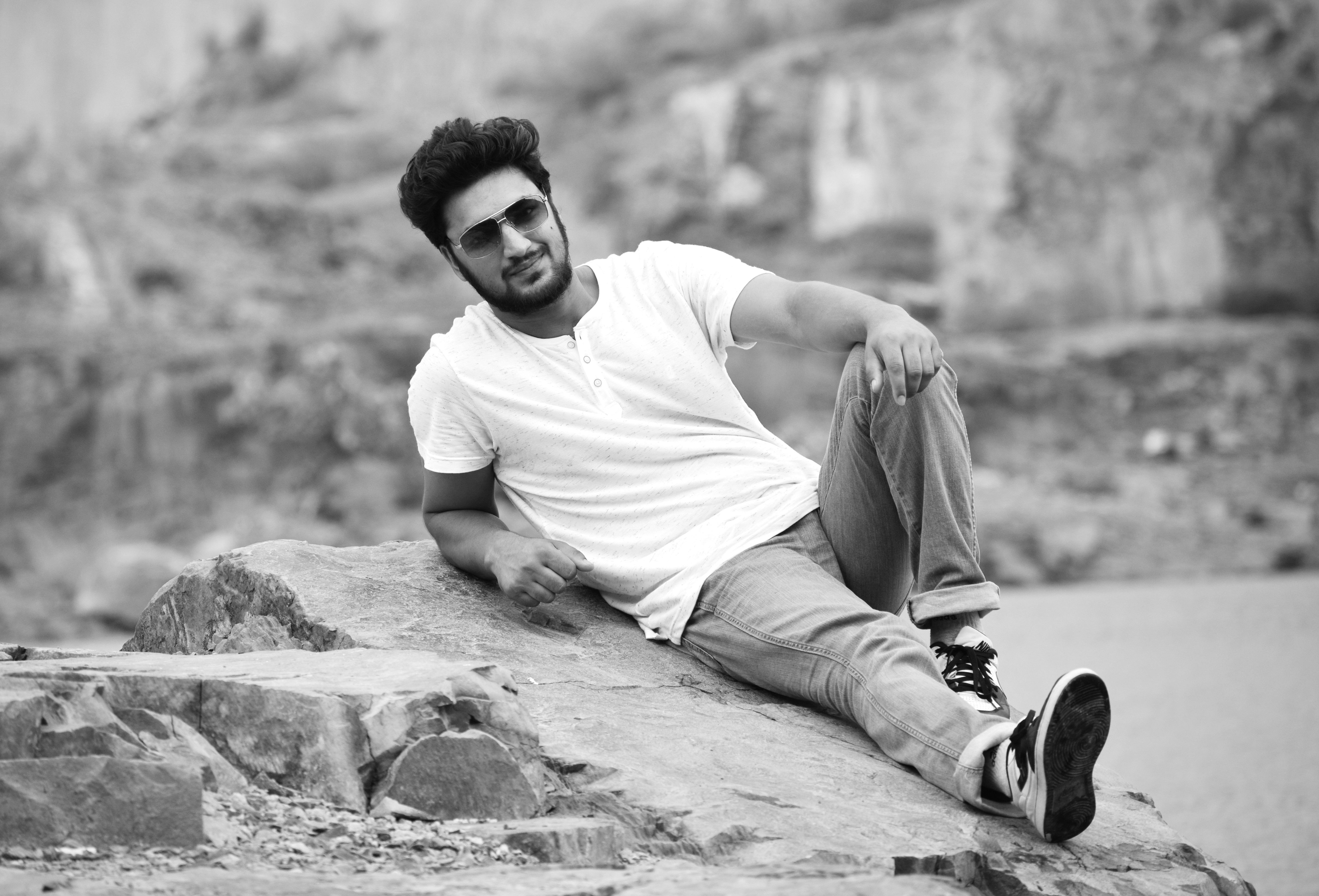 Black and White Photo of a Man Lying on a Rock · Free Stock Photo