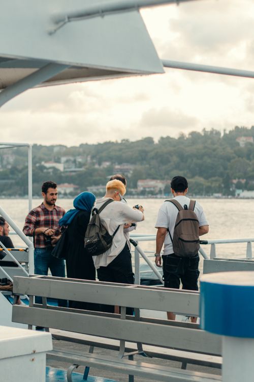 Free A diverse group of people enjoying a ferry ride with scenic harbor views, highlighting travel and leisure. Stock Photo