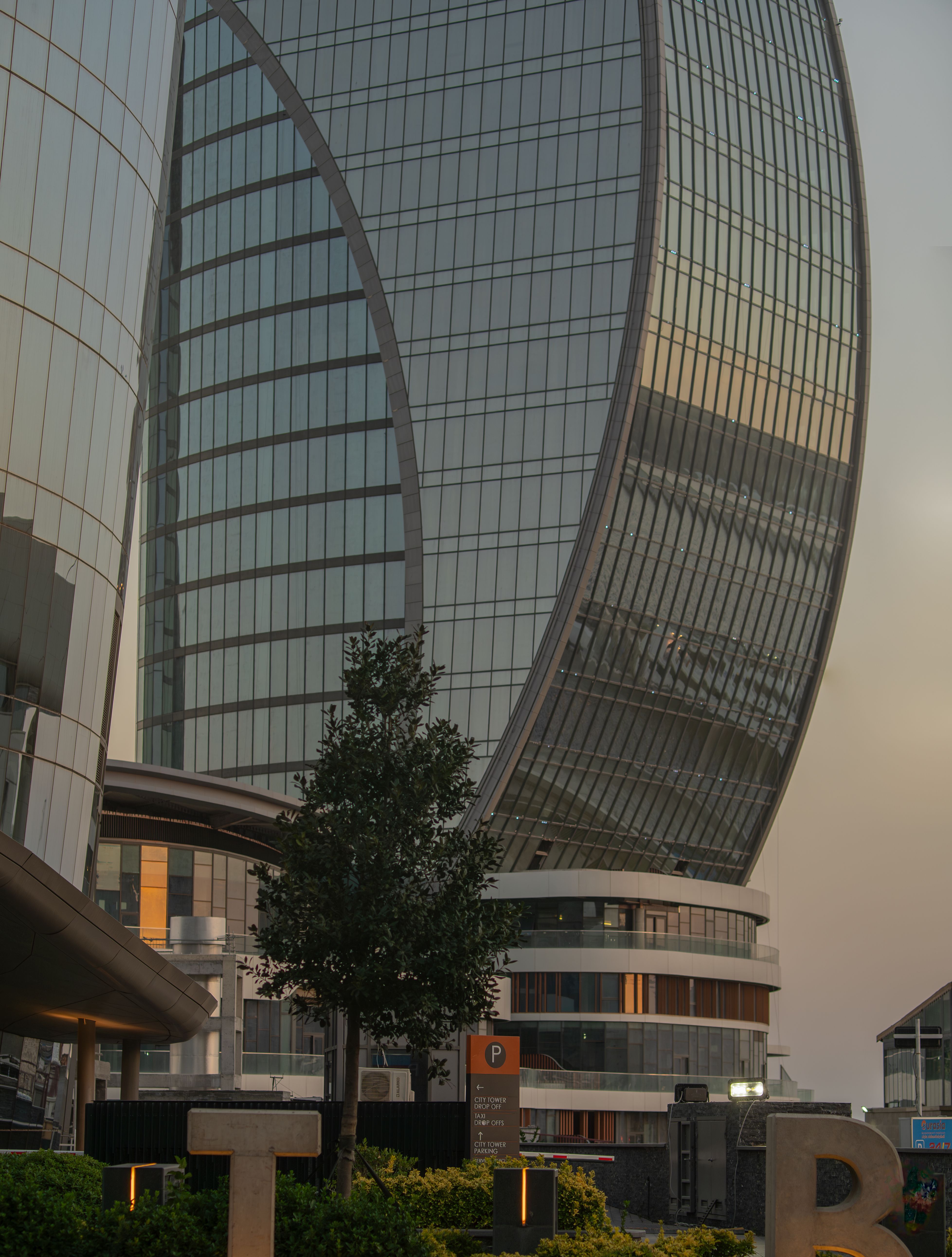 Showcasing modern architecture with a curved facade at sunset, this urban scene captures the essence of contemporary city life.