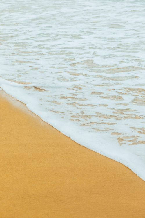 Free Calm ocean waves meet golden sand on a serene beach in Baku, Azerbaijan. Stock Photo
