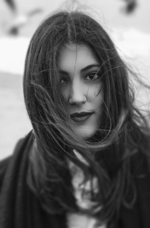Free Black and white portrait of a woman with tousled hair and confident expression. Stock Photo