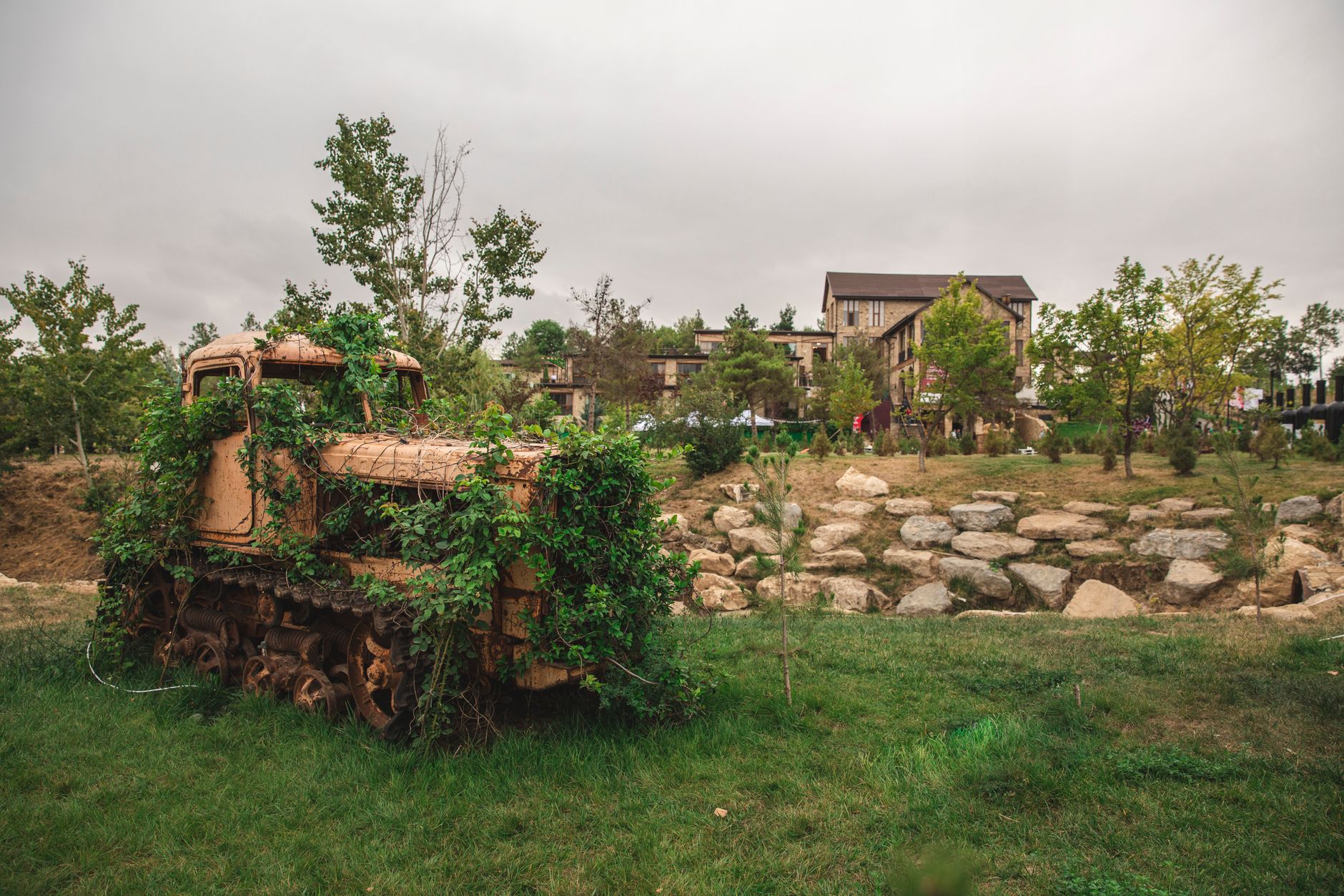 Overgrown rusty tractor in lush green countryside of Shamakhi, Azerbaijan.