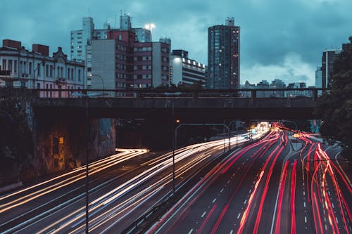 бесплатная Серая бетонная дорога со зданиями при световой экспозиции Стоковое фото
