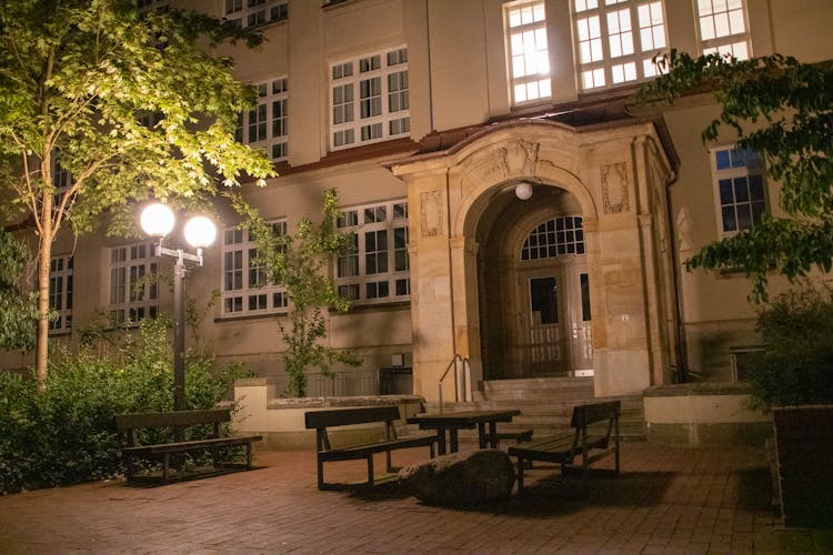 Benches And Table Near Building At Night