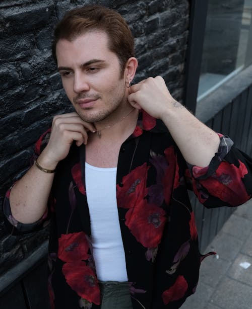 Man in Floral Shirt Fixing Neck Chain