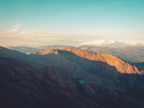 A breathtaking view of rugged mountains under an expansive sky at sunset.