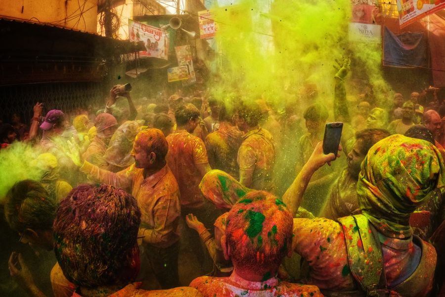 Colorful Holi festival with people enjoying in a lively urban street.
