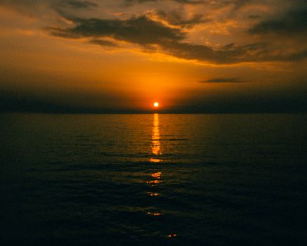 Captivating view of a sunset over the ocean, casting golden hues on the water.