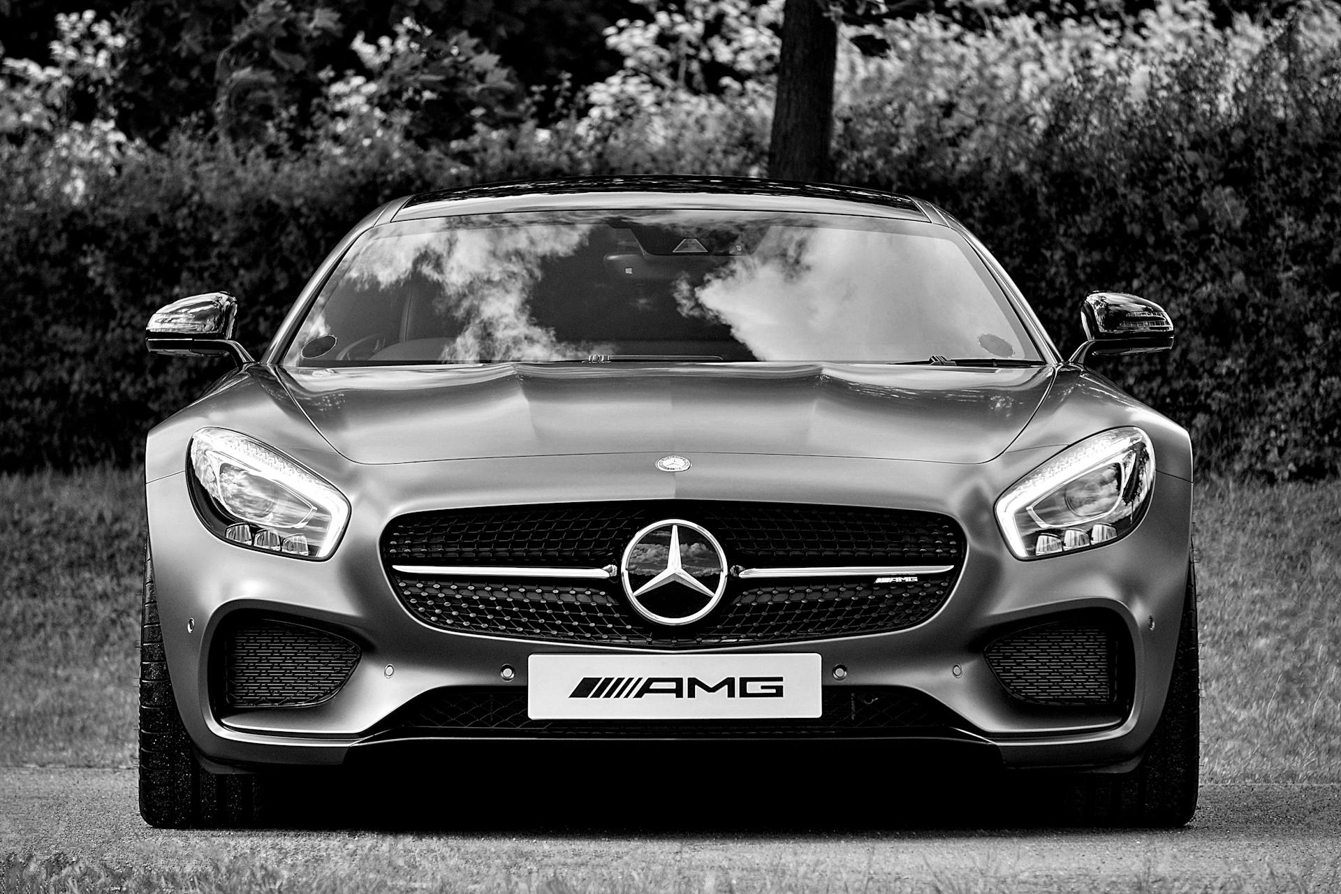 Elegant black and white photo of a parked Mercedes AMG sports car highlighting its design.