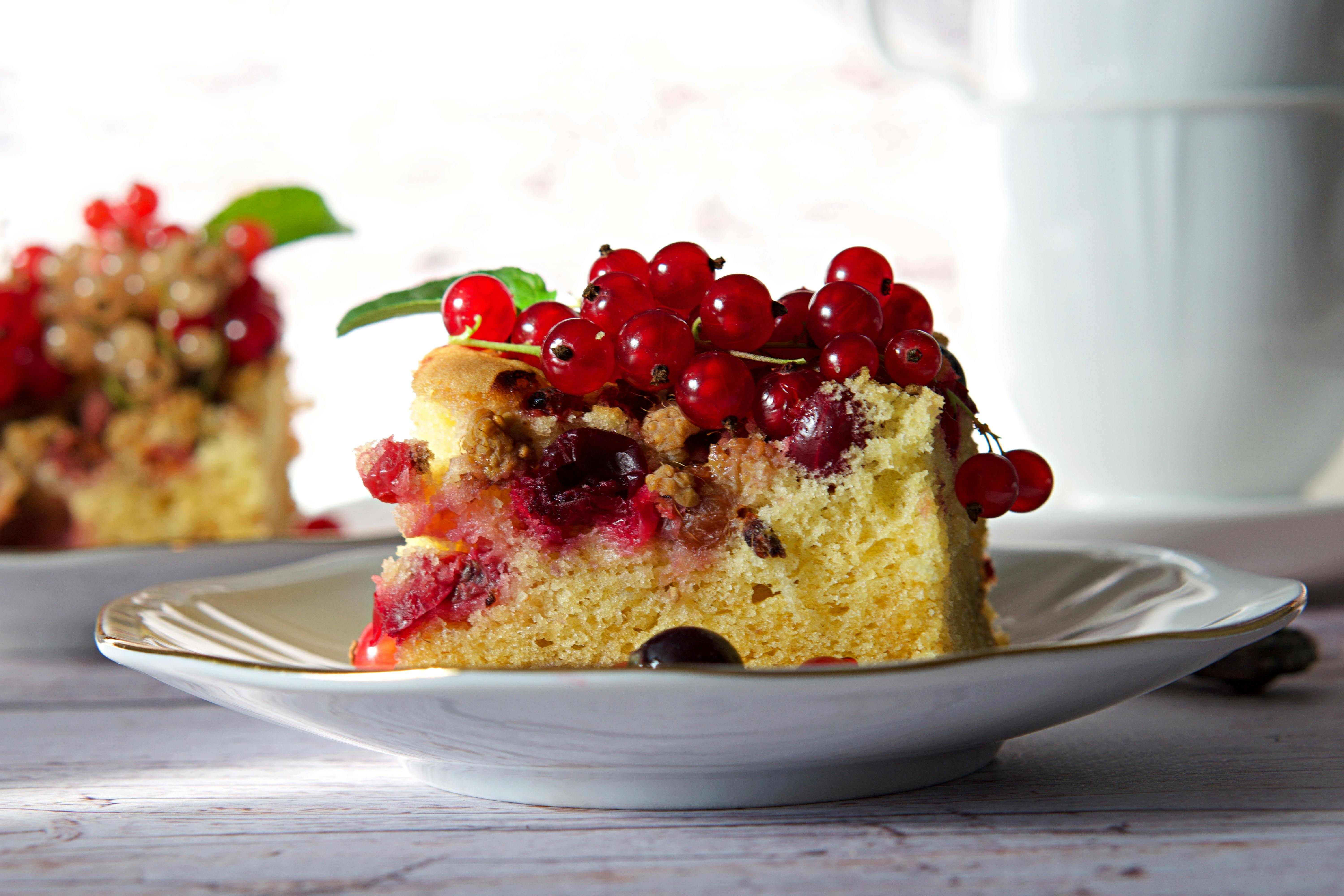 A close-up of a delicious berry-topped cake slice on a stylish plate, perfect for pastry lovers.