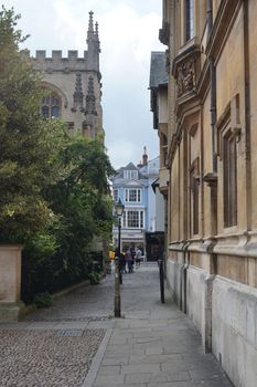 A narrow picturesque alley in Oxford, England, showcasing classic architecture and cobblestone streets.