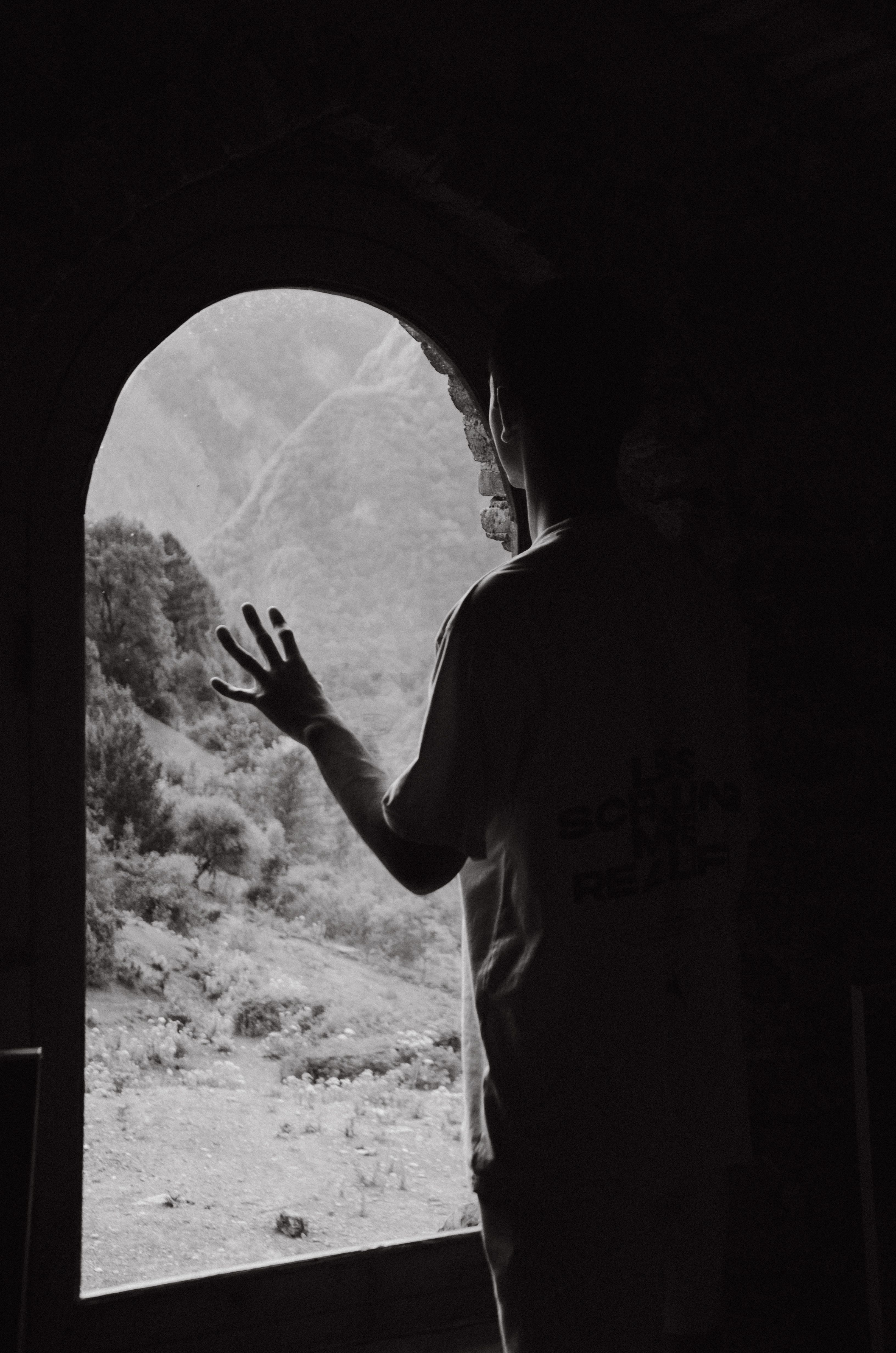A person's silhouette reaching out to a stunning view through an arched window in Baku, Azerbaijan.