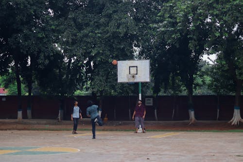 Young Men Playing Basketball in a Courtyard